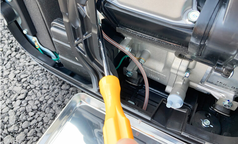 ドレンスクリュをプラスドライバーでゆるめる写真